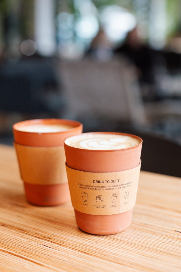 Two gaeastar clay cups on a wooden table 